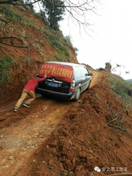  由于地震原因，道路崎嶇，再好的車也要靠人力推才能勉強爬上坡。